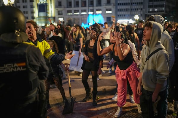 Demonstrators confront riot police during a protest organized by social and civic groups, denouncing the handling of recent flooding under the slogan "Mazón, Resign," aimed at the president of the regional government Carlos Mazon, in Valencia, Spain, Saturday, Nov. 9, 2024. (AP Photo/Emilio Morenatti)