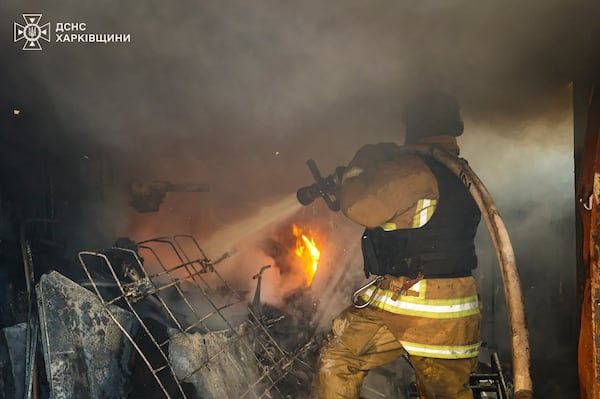 In this photo provided by the Ukrainian Emergency Service, a firefighter works to extinguish the fire following a Russian rocket attack in Kharkiv, Ukraine, Friday, March 7, 2025. (Ukrainian Emergency Service via AP)