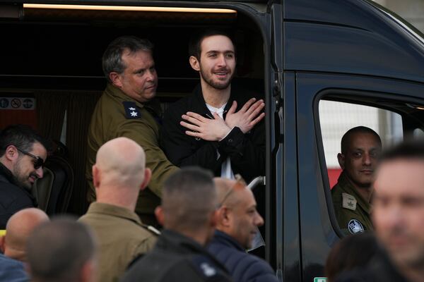 Freed Israeli hostage Omer Shem Tov gestures from a van as he arrives at Beilinson hospital in Petah Tikva, Israel, after he was released from Hamas captivity in the Gaza Strip, Saturday, Feb. 22, 2025. (AP Photo/Ohad Zwigenberg)