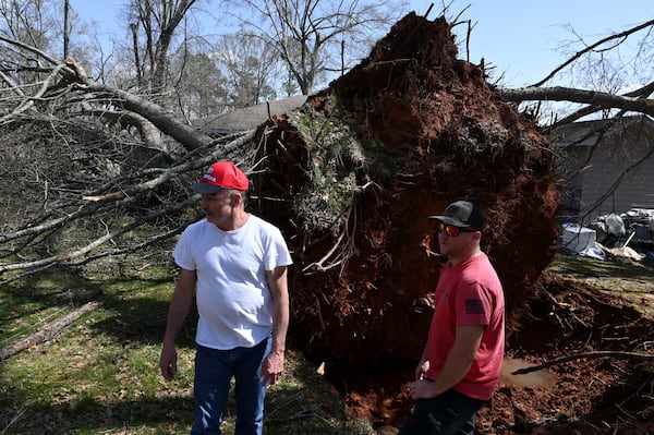 Clifford White (left), home owner, consults with Aaron Moon, owner of Down South construction company, next to the fallen tree that damaged his house after a storm passed through, Sunday, March 16, 2025, in Dallas. National Weather Service teams will be conducting a damage survey in the Paulding County/Dallas area, which sustained “pretty significant” damage from the storms, NWS Senior Meteorologist Dylan Lusk told The Atlanta Journal-Constitution on Sunday morning. (Hyosub Shin / AJC)