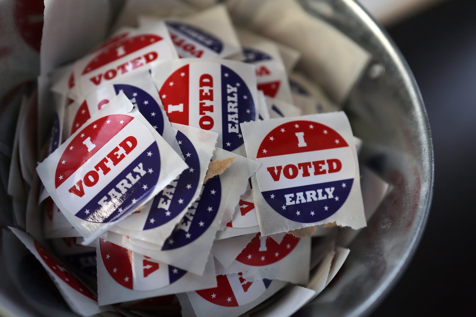 FILE "- I Voted Early" stickers sit in a bucket by the ballot box at the City of Minneapolis early voting center, Thursday, Sept. 19, 2024, in St. Paul, Minn. (AP Photo/Adam Bettcher, File)