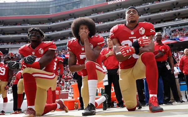 2016 AP YEAR END PHOTOS - San Francisco 49ers outside linebacker Eli Harold, left, quarterback Colin Kaepernick, center, and safety Eric Reid kneel during the national anthem before an NFL football game against the Dallas Cowboys in Santa Clara, Calif., on Oct. 2, 2016. (AP Photo/Marcio Jose Sanchez, File)