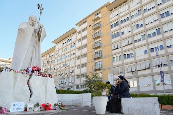 Nuns pray in front of the statue of late Pope John II outside the Agostino Gemelli Polyclinic where Pope Francis is battling pneumonia, in Rome, Saturday, Feb. 22, 2025, (AP Photo/Gregorio Borgia)