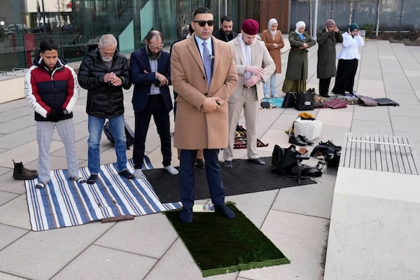 Hafsa Haider, front, Communications Coordinator of Council on American-Islamic Relations, prays with members outside the Will County Courthouse where a jury found defendant Joseph Czuba found guilty of murder and hate crime charges, Friday, Feb. 28, 2025, in Joliet, Ill. (AP Photo/Nam Y. Huh)