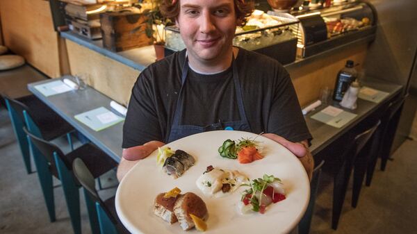 Dinner at Biwa, including a sashimi sampler, held by chef Karl Krause.  (Steve Ringman/Seattle Times/TNS)