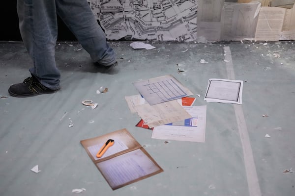 Archive images are on the floor during the preparation of a mural by French street artist Shuck One for the exhibition "Paris Noir", at the Centre Pompidou Museum, in Paris, Tuesday, Feb. 18, 2025. (AP Photo/Thibault Camus)