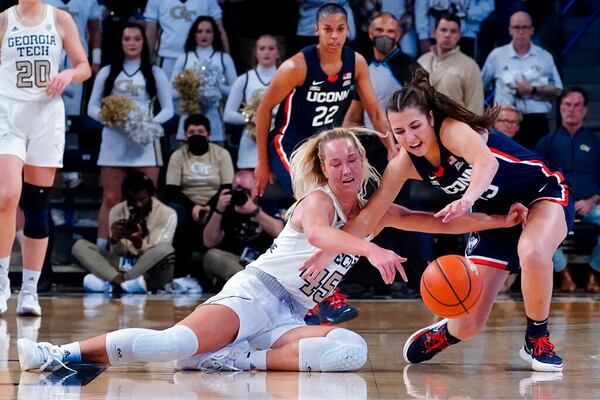 Georgia Tech forward Digna Strautmane (45) and Connecticut guard Caroline Ducharme vie for a loose ball during the first half of an NCAA college basketball game Thursday, Dec. 9, 2021, in Atlanta. (AP Photo/John Bazemore)