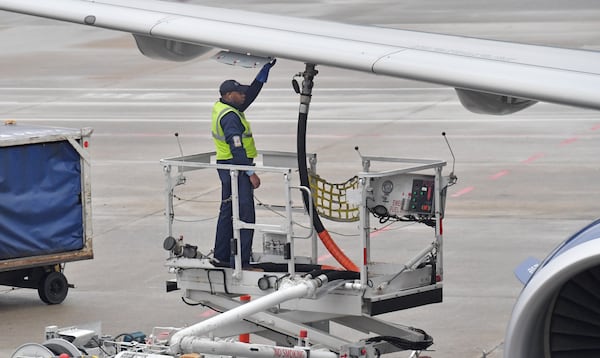 A member of a Delta ground crew prepares a jet for departure at Hartsfield-Jackson International Airport in this February file photo. HYOSUB SHIN / HSHIN@AJC.COM