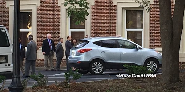 Lawyers for the prosecution and defense join Judge Mary Staley Clark in examining Justin Ross Harris' SUV outside the Glynn County Courthouse in Brunswick, Ga., during Harris' murder trial on Thursday, Oct. 27, 2016. The SUV was being prepared for inspection by jurors. (via Ross Cavitt / WSB-TV)