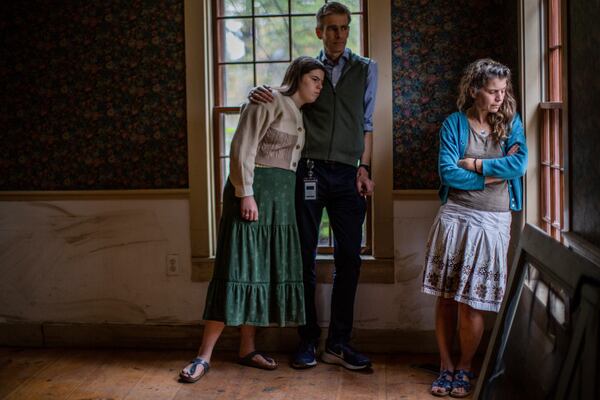 Lila, left, John and Jenny Mackenzie pose for a photo in their flood-damaged house in Peacham, Vt. on Sept. 23, 2024. (AP Photo/Dmitri Beliakov)