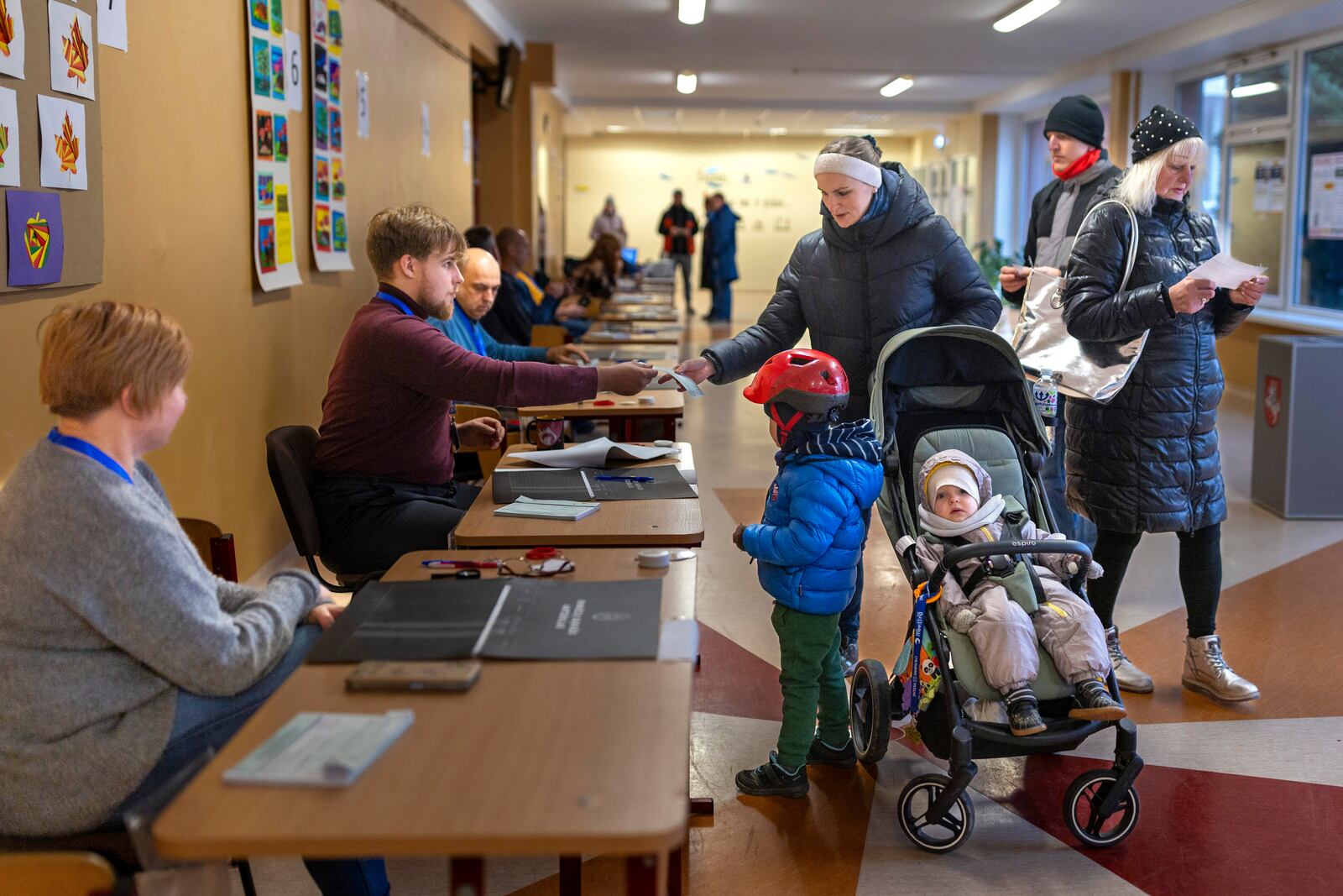 Local residents arrive to cast their ballots at a polling station during a second round of voting in parliamentary election, in Vilnius, Lithuania, Sunday, Oct. 27, 2024. (AP Photo/Mindaugas Kulbis)