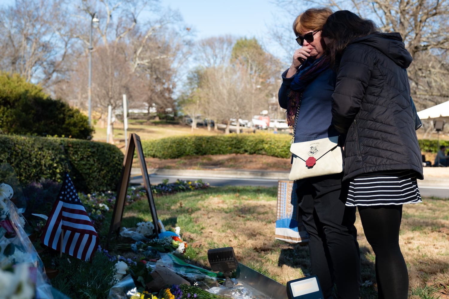 Marilyn Whitmer, who was born and raised in Atlanta, is comforted by her daughter Savannah as she becomes emotional while visiting a memorial to former President Jimmy Carter at the Carter Center in Atlanta on Monday, Dec. 30, 2024.   Ben Gray for the Atlanta Journal-Constitution