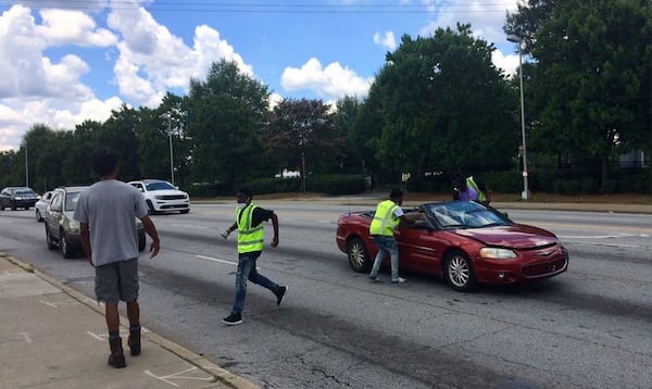 Young men sell water at the corner of Northside Drive and Joseph E. Boone Boulevard. Photo by Bill Torpy/AJC