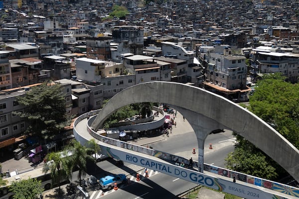 A pedestrian bridge leading to the Rocinha favela is covered by a sign that says in Portuguese: "Rio capital of the G20," in Rio de Janeiro, Wednesday, Nov. 6, 2024, ahead of the G20 Leaders' Summit. (AP Photo/Bruna Prado)