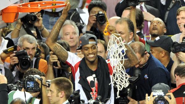 Louisville guard Kevin Ware poses for photographers after he cut the net to celebrate the Cardinals' victory over Michigan in the NCAA Championship Game April 8, 2013, at the Georgia Dorm in Atlanta.