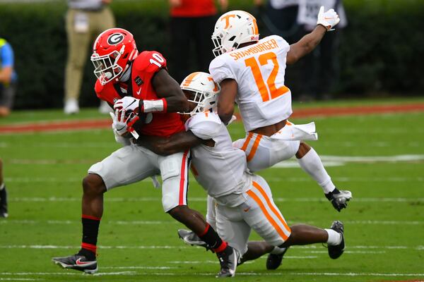 Georgia wide receiver Kearis Jackson (10) makes a catch as Tennessee defensive back Trevon Flowers (1) and defensive back Shawn Shamburger (12) defend during the first half Saturday, Oct. 10, 2020, at Sanford Stadium in Athens. (John Amis/For the AJC)