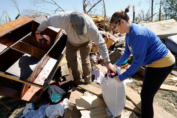 Tasha May, right, and her husband Tommy May, recover clothing from a cabinet in the tornado destroyed home of her grandparents, Sunday, March 16, 2025, Tylertown, Miss. (AP Photo/Rogelio V. Solis)