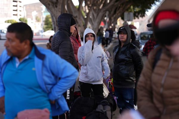 A group of people react as they see that their appointments were canceled on the U.S. Customs and Border Protection (CBP) One app, as they arrive at the border crossing in Tijuana, Mexico on Monday, Jan. 20. 2025. (AP Photo/Gregory Bull)