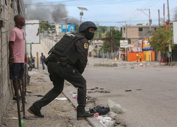 A police officer looks on during an exchange of gunfire between gangs and police in Port-au-Prince, Haiti, Monday, Nov. 11, 2024. (AP Photo/Odelyn Joseph)