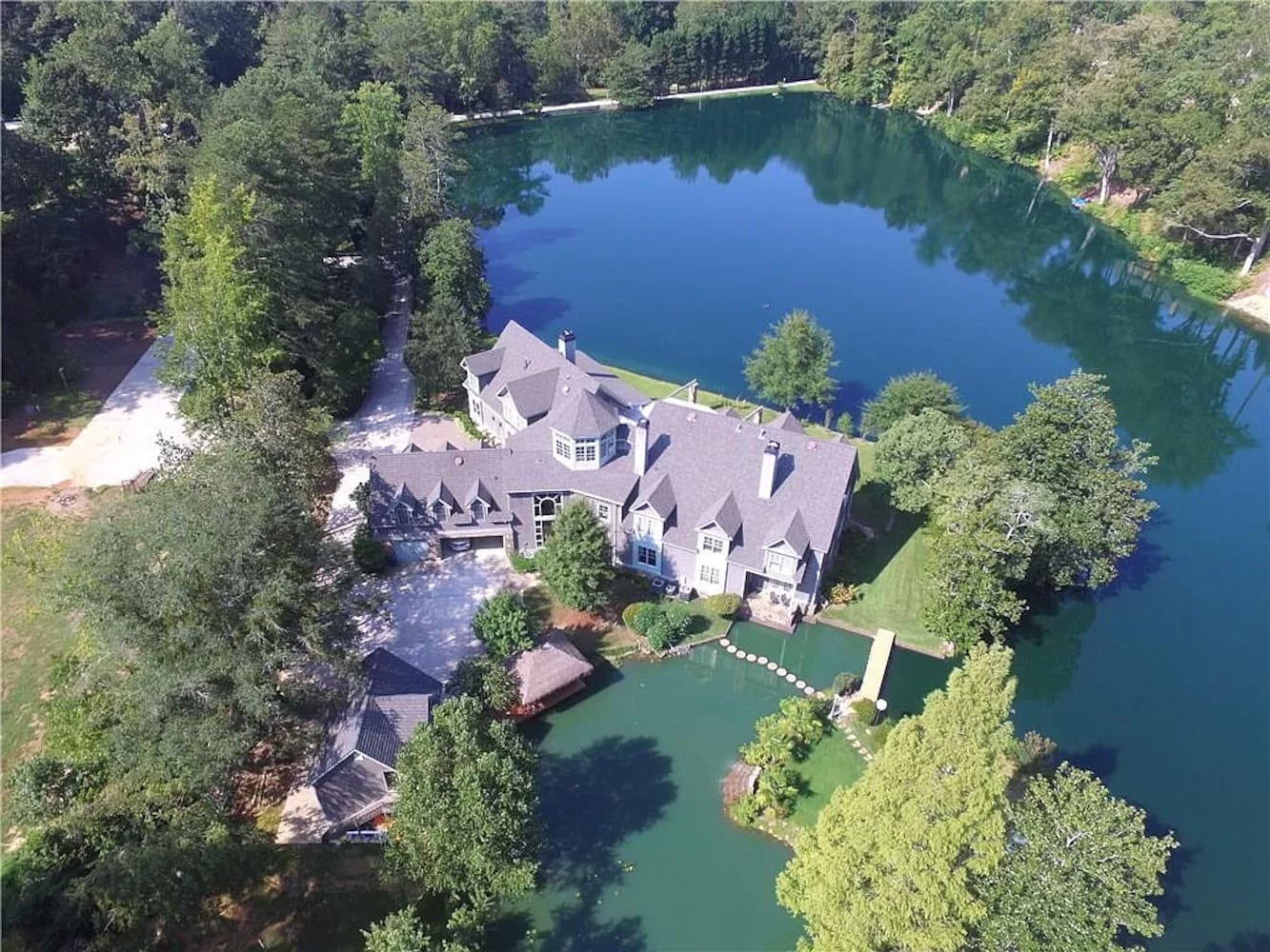 Enjoy resort-style living ITP at this $8.7M estate with private lake