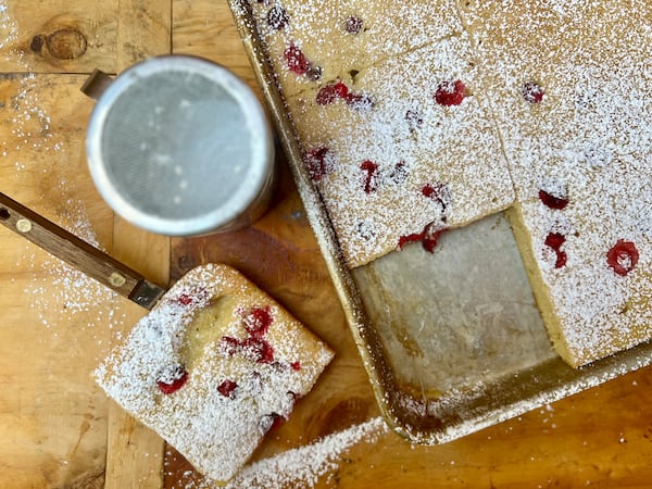 This baked buttermilk cranberry sheet pan pancake dusted with powdered sugar is an easy, elegant brunch dish to serve a crowd.
(Virginia Willis for The Atlanta Journal-Constitution)