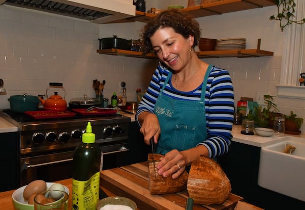 Sarah O'Brien slices a loaf of sourdough bread from her Little Tart Bakeshop. A slice of toasted bread spread with high-quality salted butter is one of her favorite snacks. (CHRIS HUNT FOR THE ATLANTA JOURNAL-CONSTITUTION)