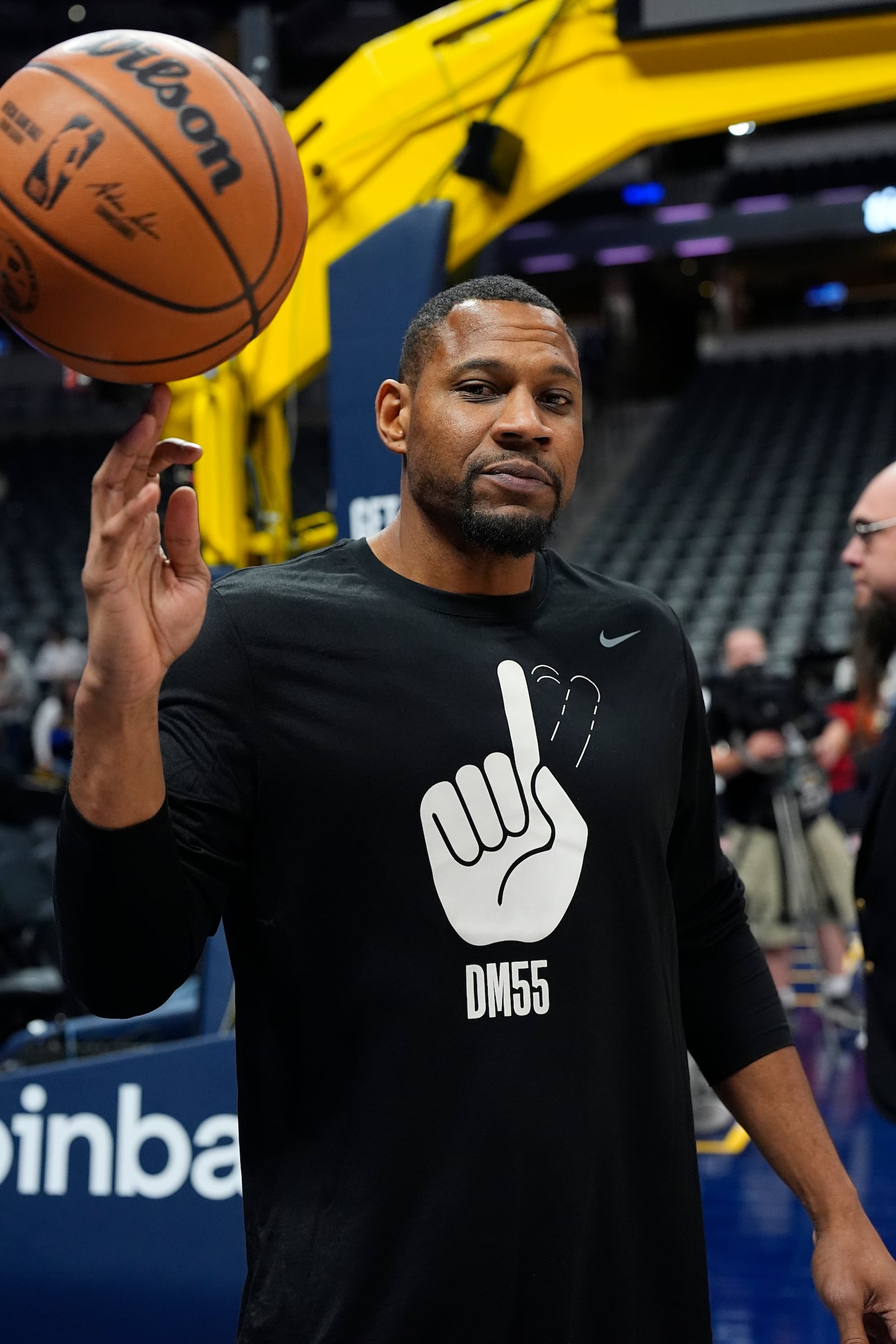 Denver Nuggets development coach Stephen Graham wears a shirt in honor of former Nuggets center Dikemba Mutombo who died last month as players warm up before an NBA basketball game against the Oklahoma City Thunder Thursday, Oct. 24, 2024 in Denver. (AP Photo/David Zalubowski)