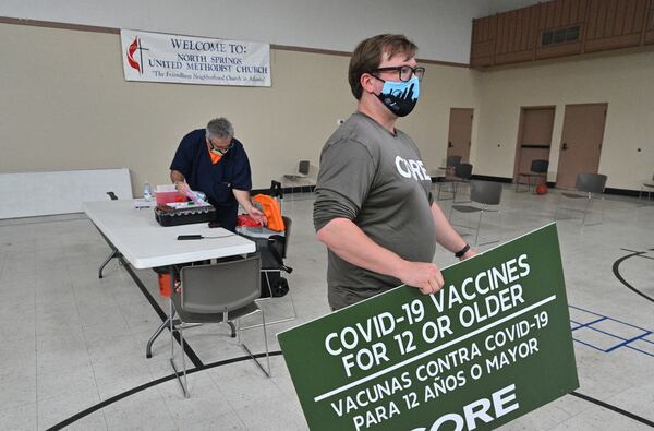 Riley Erickson (foreground), site manager with CORE, and Jim Zvikas, R.N., start packing up after waiting for the last scheduled client showing up at North Springs United Methodist Church in Sandy Springs on Thursday. (Hyosub Shin / Hyosub.Shin@ajc.com)