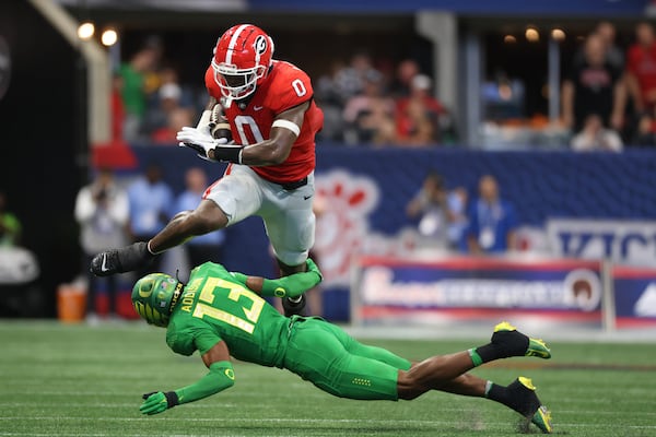 090322 Atlanta, Ga.: Georgia Bulldogs tight end Darnell Washington (0) runs after a catch against Oregon Ducks defensive back Bryan Addison (13) during their game at Mercedes Benz Stadium, Saturday, September 3, 2022, in Atlanta. Mitchell had four catches for 65 yards and one touchdown. Georgia won 49-3. (Jason Getz / Jason.Getz@ajc.com)