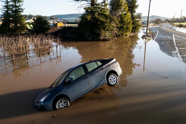 FLIE - A vehicle is partially submerged in floodwater along State Route 121 following an atmospheric river event near Schellville in Sonoma, Calif., Feb. 5, 2025. (Stephen Lam/San Francisco Chronicle via AP)