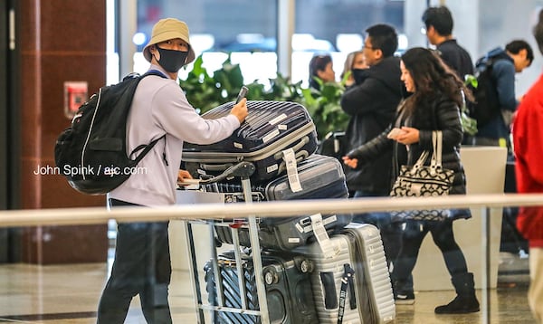 John Kim from Korea arrives at the Atlanta International Terminal wearing a mask as a precaution against coronavirus.