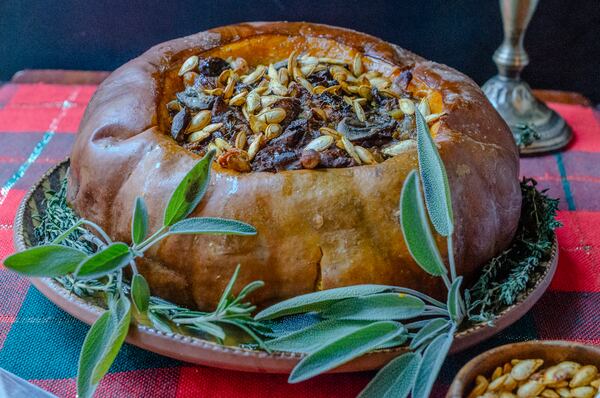 Vegan Stuffed Roast Pumpkin is a stunning addition to the holiday table. (Virginia Willis for The Atlanta Journal-Constitution)