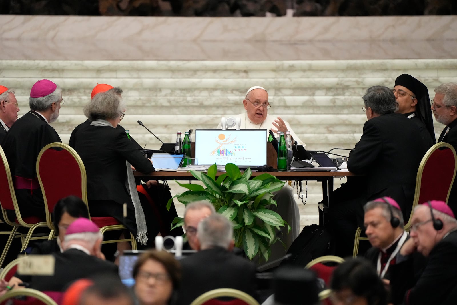 Pope Francis, background center, attends the works of the second session of the 16th General Assembly of the Synod of Bishops in the Paul VI hall, at the Vatican, Saturday, Oct. 26, 2024. (AP Photo/Gregorio Borgia)