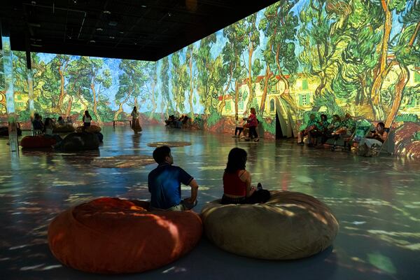 People take in the main room of Van Gogh: The Immersive Experience at Exhibition Hub Art Center Atlanta in Doraville on Monday, July 31, 2023.   (Ben Gray / Ben@BenGray.com)