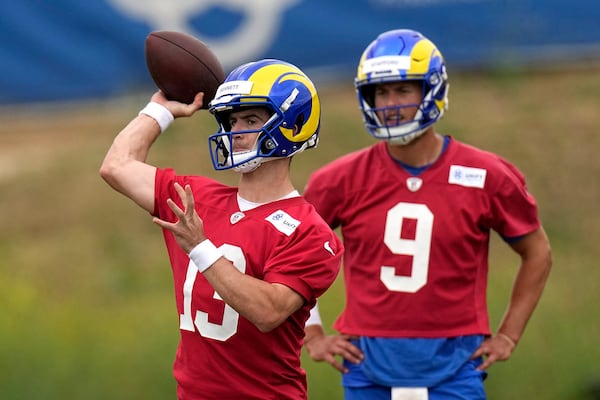 Los Angeles Rams backup quarterback Stetson Bennett, left, passes as quarterback Matthew Stafford watches during the NFL football team's organized activities Wednesday, May 31, 2023, in Thousand Oaks, Calif. (AP Photo/Mark J. Terrill)