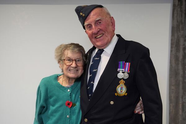 Michael Woods, 100-year-old World War II veteran, poses with his wife Mary during an interview in Dunstable, Bedfordshire, England, Tuesday, Nov. 5, 2024. (AP Photo/Kin Cheung)