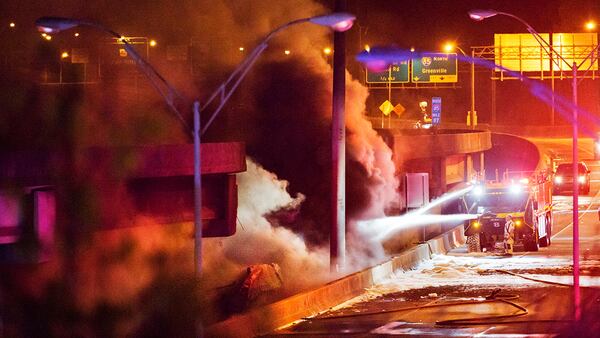 Smoke billows from a section of an overpass that collapsed from a large fire on Interstate 85 in Atlanta, Thursday, March 30, 2017. Witnesses say troopers were telling cars to turn around on the bridge because they were concerned about its integrity. Minutes later, the bridge collapsed. (AP Photo/David Goldman)