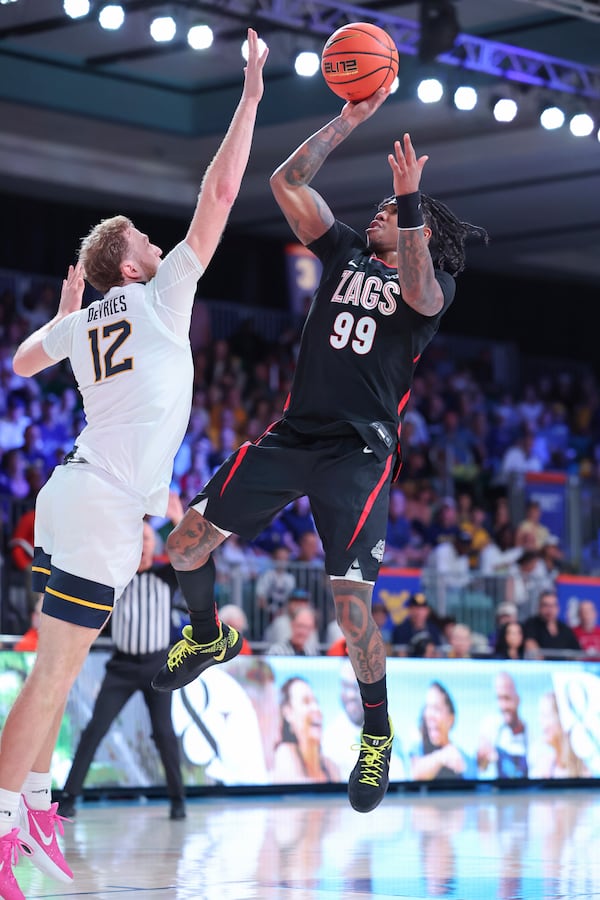 In this handout provided by Bahamas Visual Services, Gonzaga guard Khalif Battle (99) goes to the basket against West Virginia guard Tucker DeVries (12) during an NCAA college basketball game at the Battle 4 Atlantis tournament in Paradise Island, Bahamas Wednesday, Nov. 27, 2024. (Tim Aylen/Bahamas Visual Services via AP)