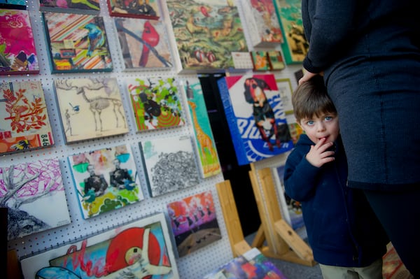 Cade Green (left) holds onto his mother Marlene as she looks at the Urban Attic booth during the 9th Annual Brookhaven Arts Festival on Saturday, Oct. 20, 2012.