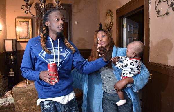 Jamarco Gibson, who survived an overdose on counterfeit Percocet in June, shares his story as his mother Timiko Jackson holds her grandson Lamar Jones at their home in Macon. HYOSUB SHIN / HSHIN@AJC.COM