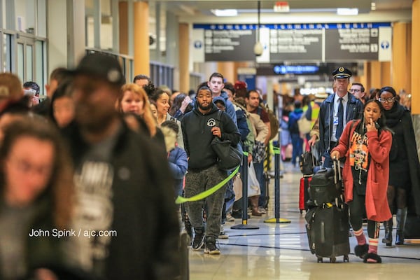 Passengers wait in the North Terminal security line at Hartsfield-Jackson International Airport on Monday, December 18, 2017