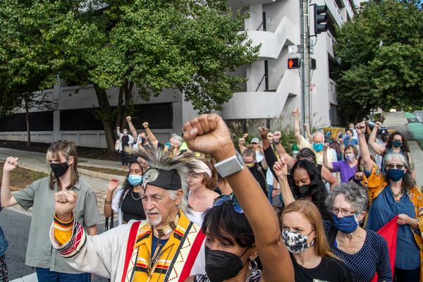 10/11/2021 — Decatur, Georgia — Demonstrators march along West Trinity Place in Decatur as they protest for the removal of a United Daughters of the Confederacy monument located in downtown Decatur, Monday, October 11, 2021. (Alyssa Pointer/ Alyssa.Pointer@ajc.com)