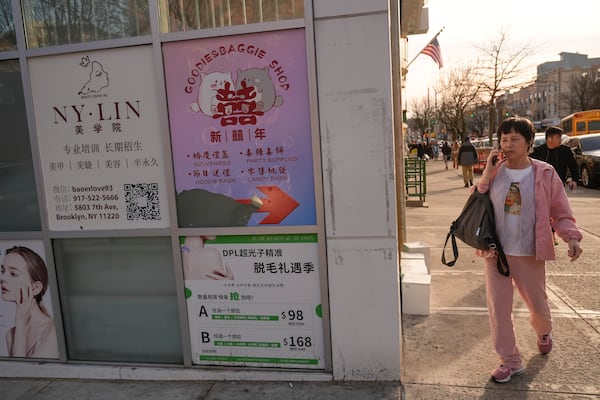 Signs in Chinese and English are displayed the Brooklyn borough of New York, Friday, Feb. 28, 2025. (AP Photo/Seth Wenig)