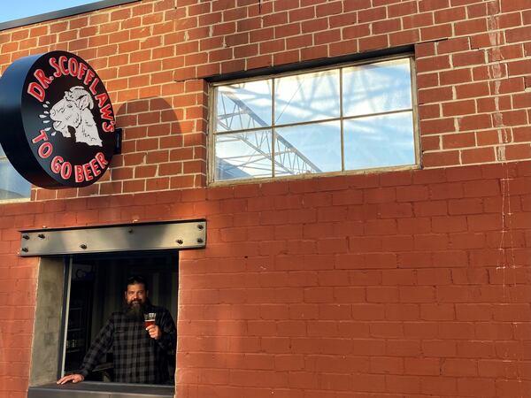 Scofflaw co-founder and chief brewing officer Travis Herman shows off the to-go window at the new Dr. Scofflaw’s at the Works. Bob Townsend for The AJC