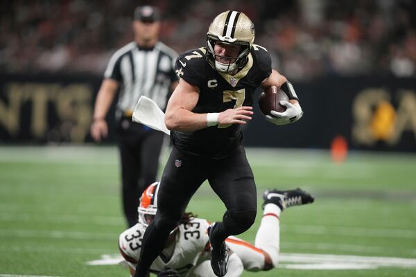 New Orleans Saints tight end Taysom Hill (7) carries in for a touchdown pst Cleveland Browns safety Ronnie Hickman (33) in the second half of an NFL football game in New Orleans, Sunday, Nov. 17, 2024. (AP Photo/Gerald Herbert)