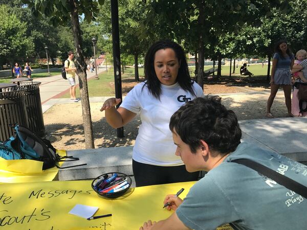 Georgia Tech student Maggie Kelley talks to a classmate about a table she and friends organized for students to write messages of support for the family of Scout Schultz and the Georgia Tech Police Department. (ERIC STIRGUS / ESTIRGUS@AJC.COM)