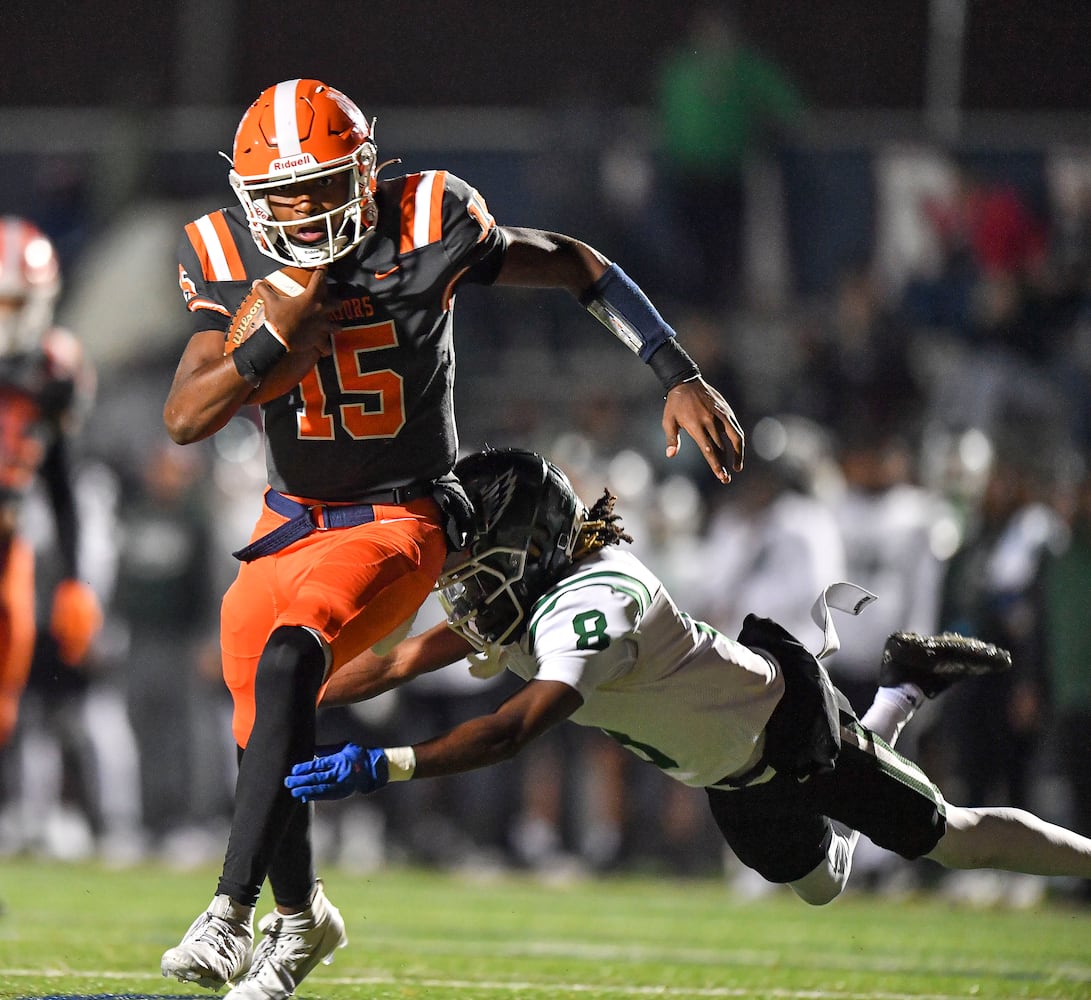 North Cobb’s quarterback Nick Grimstead (15) avoids a tackle by Collins Hill’s Charles Goodman (8) during the first half of play Friday, Nov. 10, 2023 at North Cobb High School. (Daniel Varnado/For the AJC)