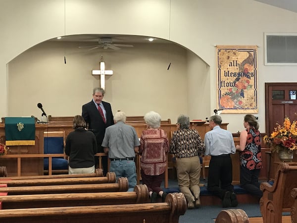 Members of Lovejoy Memorial United Methodist Church in Newnan take Communion during a recent service. With the church’s very small membership, its future direction is in question. SHELIA POOLE / SPOOLE@AJC.COM