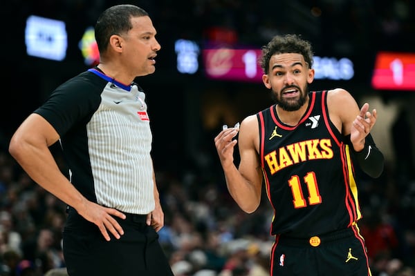 Atlanta Hawks guard Trae Young disputes a call with official Nate Green in the first half of an NBA basketball game against the Cleveland Cavaliers, Wednesday, Nov. 27, 2024, in Cleveland. (AP Photo/David Dermer)