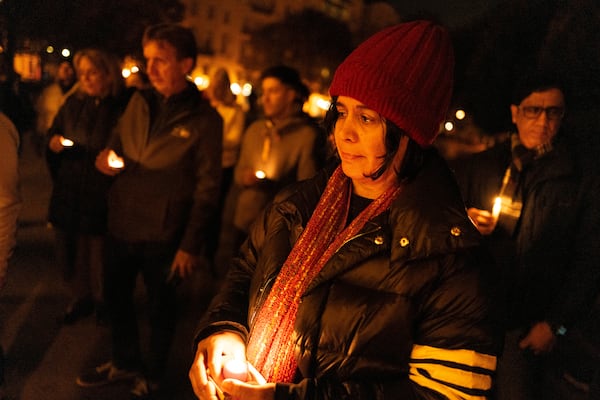 Friends hold candles while remembering Mackenzie Michalski, an 31-year-old American tourist who was murdered while on vacation, during a candlelight vigil in Budapest, Hungary, Saturday, Nov. 9, 2024. (AP Photo/Bela Szandelszky)